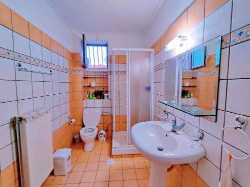 a bathroom with a sink and a toilet at Artemis Cinema Garden Near Airport & Sea in Artemida