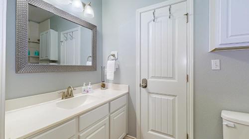 a white bathroom with a sink and a mirror at BC604 Roomy Townhome, Outdoor Seating, Shared Heated Pool with Water Slide in Port Aransas