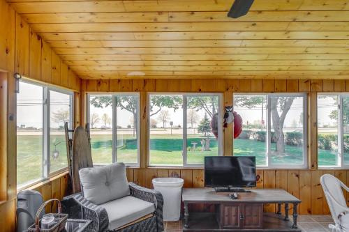 a screened in porch with a tv and a couch and a table at Two Rivers Thiede House - Walk to Lake Michigan! in Two Rivers