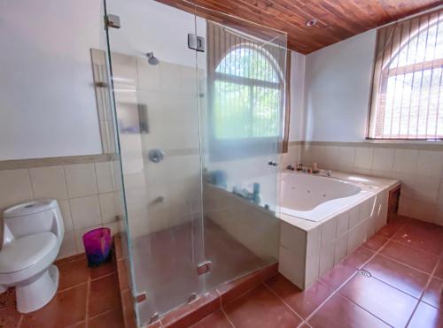a bathroom with a shower and a tub and a toilet at Casa Alice Marbella Lodge in Marbella