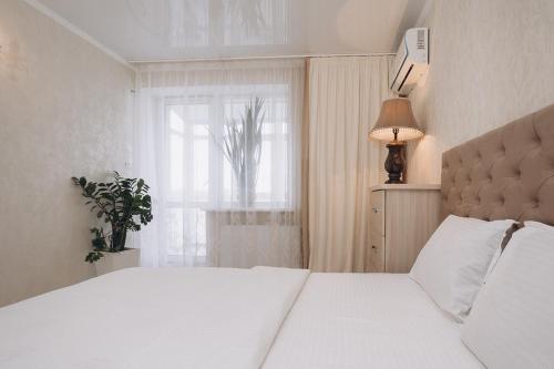 Un dormitorio con una gran cama blanca y una ventana en VIP Apartment on Diemiana Korotchienko, en Sumy