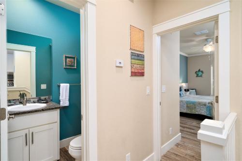 a bathroom with a sink and a toilet and a bedroom at After Dune Delight in Port Aransas
