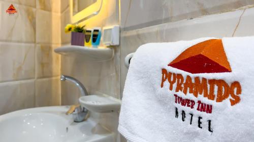 a towel that says happy new year on a bathroom sink at Pyramids Tower view inn in Nazlat as Sammān