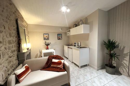 シャンプニエにあるGîte aux portes d'Angoulêmeのリビングルーム(白いソファ付)、キッチンが備わります。