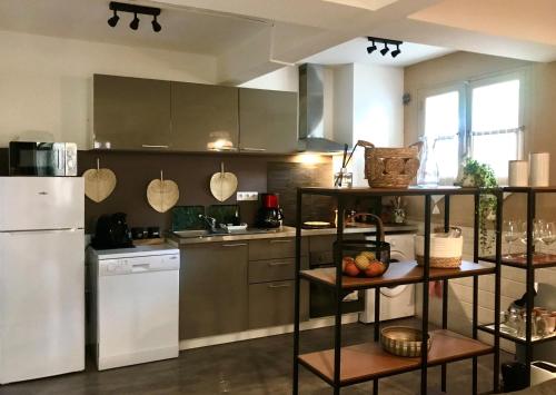 a kitchen with a white refrigerator and a counter at Le Patio, Climatisation Terrasse Wi-Fi Netflix 15 mn coeur de ville in Béziers