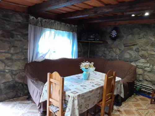 a table in a room with a stone wall at Котеджі "У Яни" in Yablunytsya