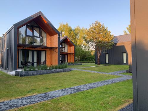 a house with a stone walkway in front of a yard at Baltic Homes Lubiatowo in Lubiatowo