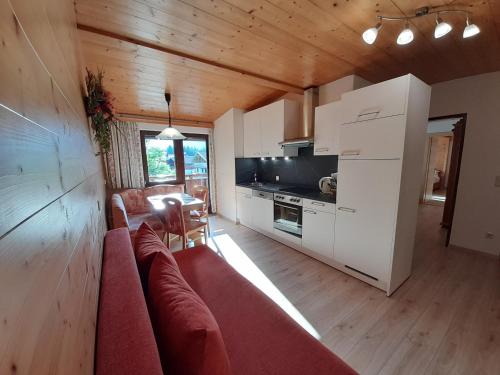 a living room with a couch and a kitchen at Neubauhof in Reith im Alpbachtal