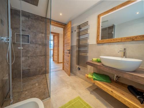 a bathroom with a sink and a glass shower at Deschana Lodge in Livigno