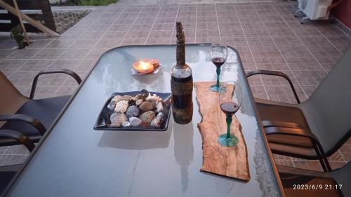 un tavolo con una bottiglia di vino e un piatto di cibo di HARI'S NEST CORFU a Marathias