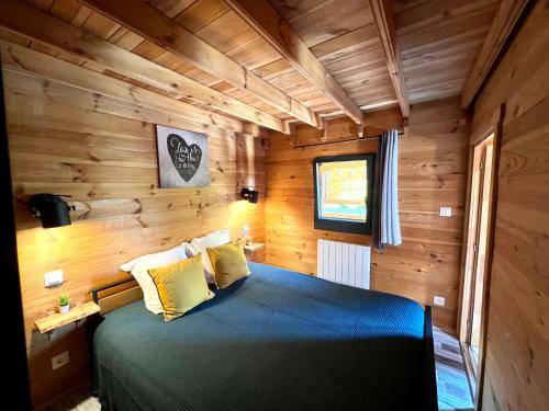 a bedroom with a blue bed in a wooden room at Gites d'Armor in Treguidel