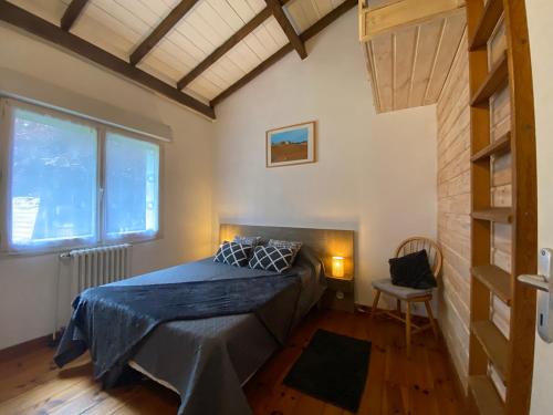 une chambre avec un lit, une fenêtre et une chaise dans l'établissement La maison de Mamie, à Pessac