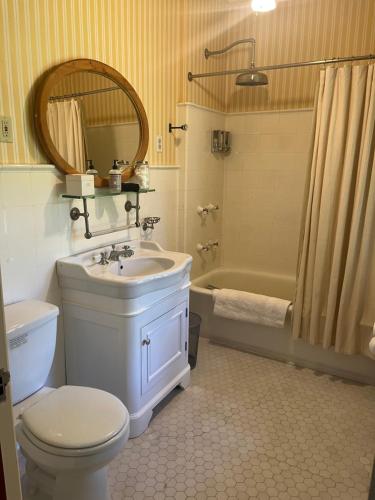 Rushmore Estate في Woodbury: حمام مع حوض ومرحاض وحوض استحمام