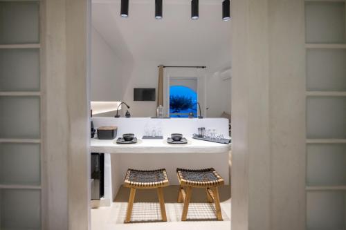 a bathroom with a sink and two stools at SEAMENTO suites in Tinos Town