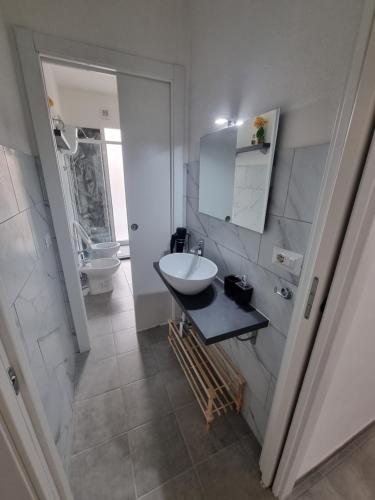 a white bathroom with a sink and a toilet at Mito apartment in Cagliari