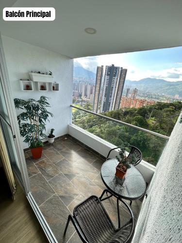 a balcony with a table and chairs and a view at Hermoso y Lujoso Apartamento en Sabaneta in Sabaneta