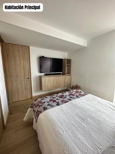 a bedroom with a bed and a flat screen tv at Hermoso y Lujoso Apartamento en Sabaneta in Sabaneta