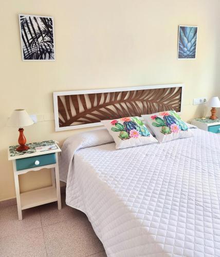 a bedroom with a white bed and a nightstand with a bed sidx sidx sidx at Hostal Noray in Sant Feliu de Guixols