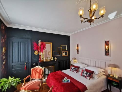 a bedroom with a large bed and a chandelier at BELLE REINE - 3 APPARTEMENTS EN COEUR DE CENTRE-VILLE in Aix-les-Bains