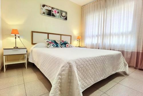 a bedroom with a large white bed with a window at Hostal Noray in Sant Feliu de Guixols