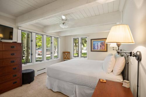 Schlafzimmer mit einem Bett mit einer Lampe und Fenstern in der Unterkunft Cottonwoods 1-D in Aspen