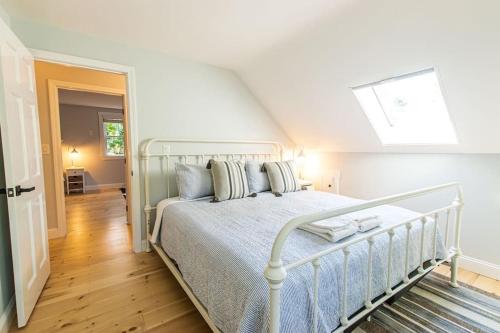 een slaapkamer met een wit bed en een dakraam bij Beautiful Home Easy Access to Beaches in Brewster