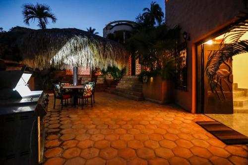 a patio with a table and chairs and a building at Casa Flamingo Cabo Luxurious Home, Spacious Rooms in El Pedregal Gated Community in Cabo San Lucas