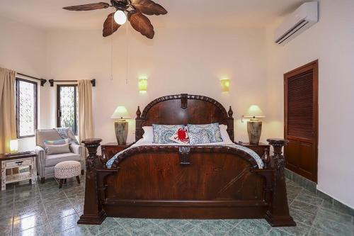 a bedroom with a large wooden bed with a ceiling fan at Casa Flamingo Cabo Luxurious Home, Spacious Rooms in El Pedregal Gated Community in Cabo San Lucas