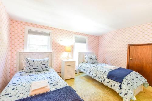 - 2 lits dans une chambre avec papier peint rose dans l'établissement Close to Bayside Game Room w Pool Table, à Brewster
