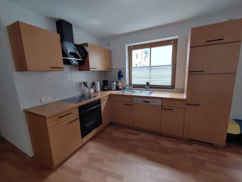 a kitchen with wooden cabinets and a sink and a window at Haus Blumenampel in Schmalkalden