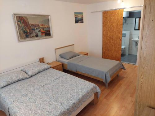 a hotel room with two beds and a bathroom at IN Kala in Rijeka