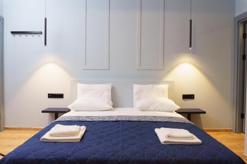 a bedroom with a bed with two towels on it at Sani Deluxe Suites - Monastiraki Square - Brand New in Athens