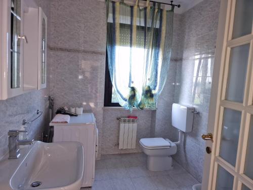 a white bathroom with a sink and a toilet at Appartamento Divino Tramonto in Altedo