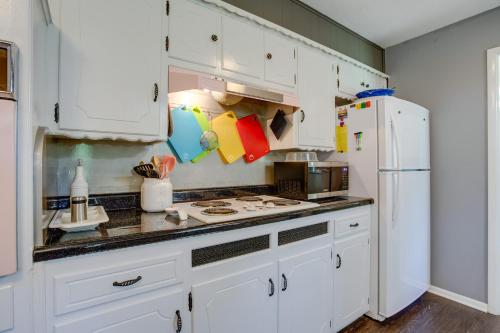 a kitchen with white cabinets and a white refrigerator at Norman Home with Yard, Walk to Park and OU Campus! in Norman
