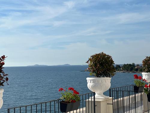 a view of the water from a balcony with flowers at Swiss Rivage Hotel in Vlorë