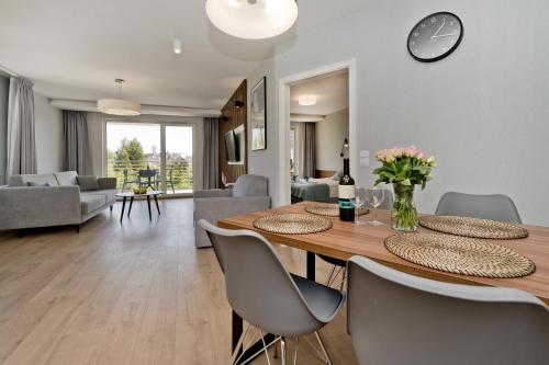 a dining room and living room with a table and chairs at BlueApart Apartamenty Na Klifie in Władysławowo