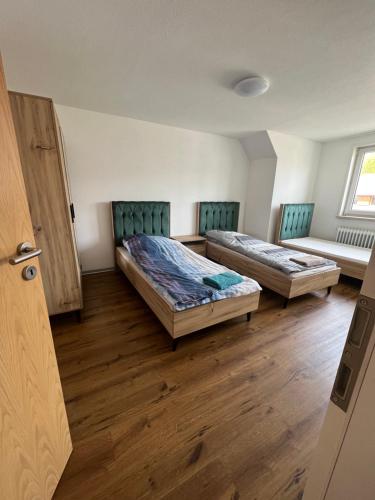 two beds in a room with wooden floors at Flori Home in Murg