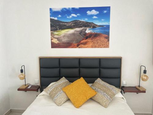 1 dormitorio con 1 cama con una foto en la pared en Sunrise IN LOFT en Playa Honda