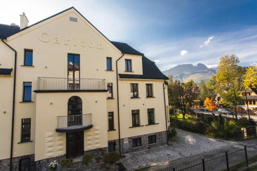 a large white building with a balcony at Willa Carlton in Zakopane