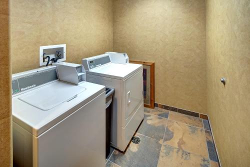uma pequena cozinha com máquina de lavar e secar roupa em Creekside Lodge at Custer State Park Resort em Custer