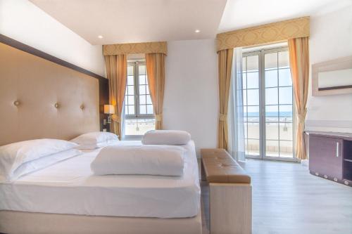 a bedroom with two beds and a large window at Park Hotel Pineta Boutique Hotel in Caorle
