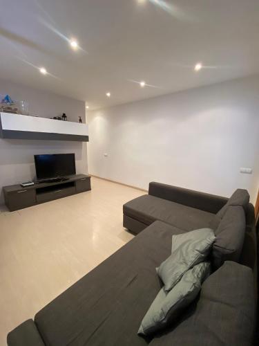 a living room with a couch and a tv at Cozy apartment at a great location! in Hospitalet de Llobregat
