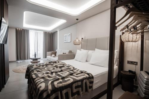 una camera d'albergo con un grande letto e una sedia di King’s & Queen’s ad Áfitos