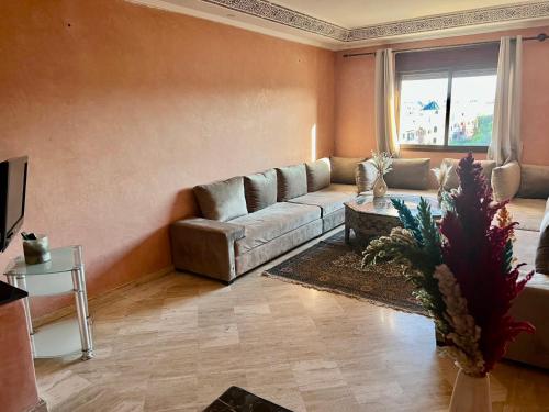 een woonkamer met een bank en een tafel bij Appartement les résidences du rêve in Marrakesh