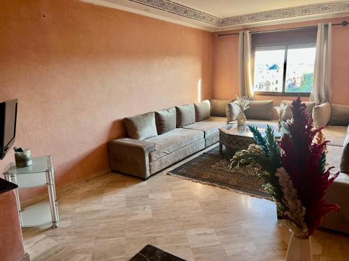 ein Wohnzimmer mit einem Sofa und einem Tisch in der Unterkunft Appartement les résidences du rêve in Marrakesch