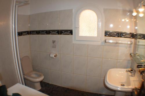 baño con aseo y lavabo y ventana en El Cisne - holiday home with private swimming pool in Benissa, en Pedramala