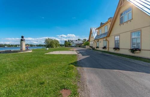 a road next to a building next to a body of water at Villa Marienholm in Haapsalu