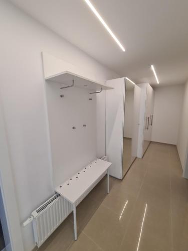 a white hallway with a bench in a room at Seesuiten Mörbisch in Mörbisch am See