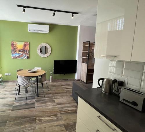 a kitchen and dining room with a table in a room at Fly Away Home condo with terrace in Qormi