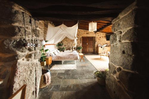 ein Schlafzimmer mit einem Bett in einem Steingebäude in der Unterkunft Apedeceo Belesar Villa, Ribeira Sacra, Galicia in Chantada